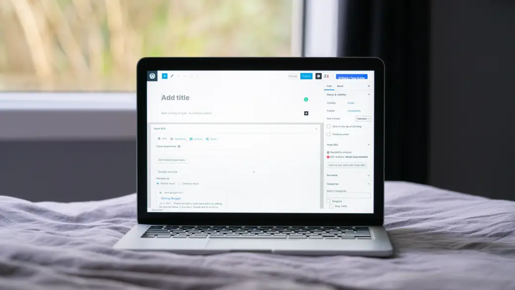 Ein Laptop mit geöffnetem WordPress-Editor steht auf einem Bett