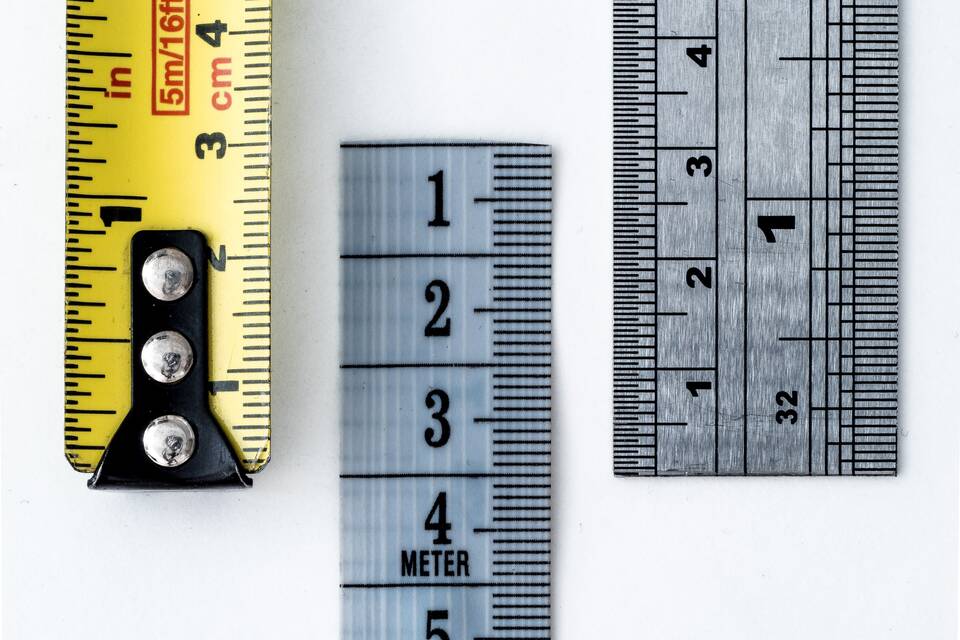 Verschiedene Lineale und Maßbänder aus Metall mit Zentimeter- und Zoll-Skalen