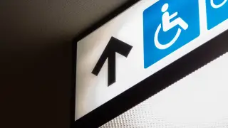 Ein Leuchtschild mit einem Pfeil nach vorne und einem Piktogramm für Behinderungen