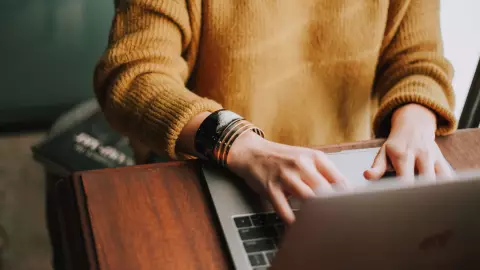 eine Frau nutzt die Tastatur ihres Laptops